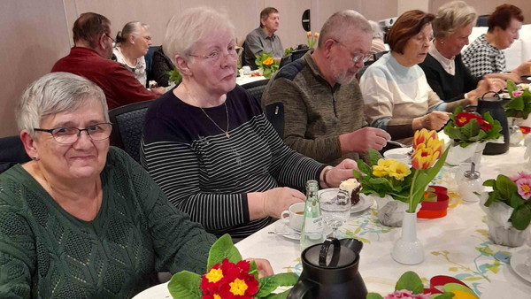 Menschen sitzen am gedeckten Tisch