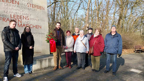 Gruppe steht vor Gedenkstätte