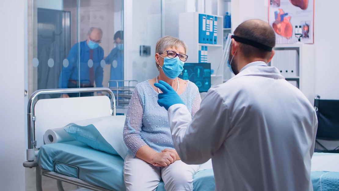 Ältere Frau im Krankenhaus spricht mit einem Arzt. 