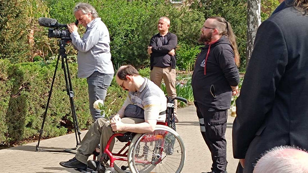 Dr. Karsten Lippmann im Rollstuhl mit Blumen in der Hand.
